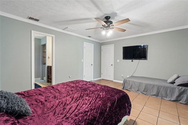 bedroom with a textured ceiling, ceiling fan, crown molding, light tile patterned flooring, and ensuite bath