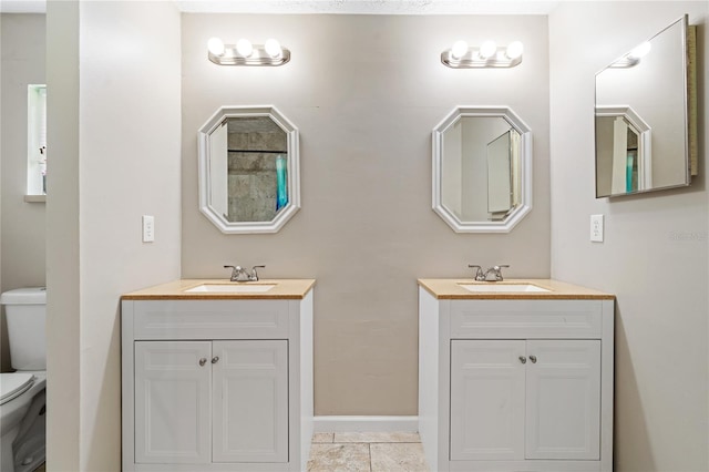 bathroom featuring double vanity, toilet, and tile patterned floors