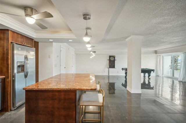 kitchen with pool table, light stone countertops, stainless steel refrigerator with ice dispenser, a tray ceiling, and ornamental molding