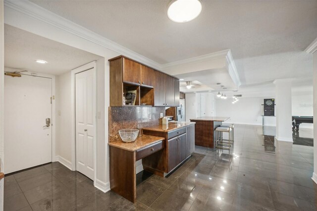 kitchen featuring ornamental molding, dark tile patterned floors, tasteful backsplash, and billiards