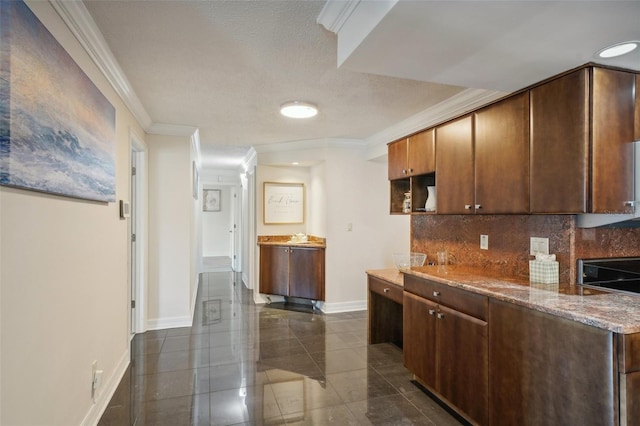 kitchen featuring crown molding, stone counters, decorative backsplash, baseboards, and stove