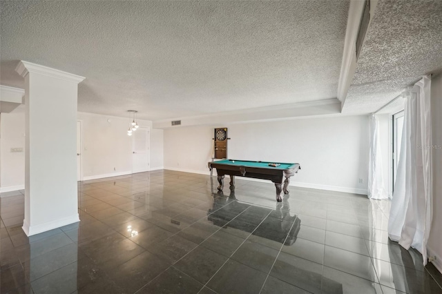 game room featuring visible vents, dark tile patterned flooring, a textured ceiling, crown molding, and baseboards