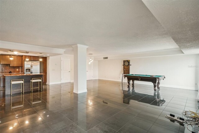 playroom with dark tile patterned floors, pool table, ornate columns, bar, and ornamental molding