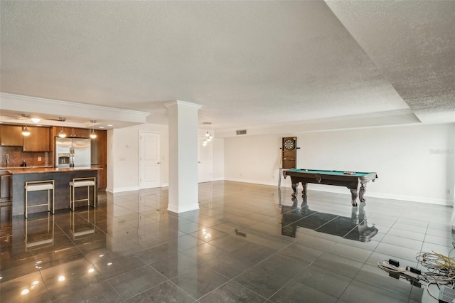 recreation room featuring dark tile patterned floors, visible vents, a textured ceiling, and baseboards