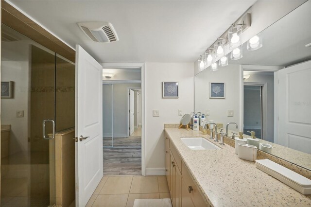 bathroom featuring vanity, tile patterned flooring, and walk in shower