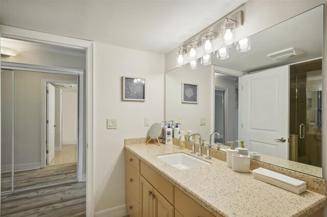 bathroom with vanity, hardwood / wood-style flooring, and walk in shower