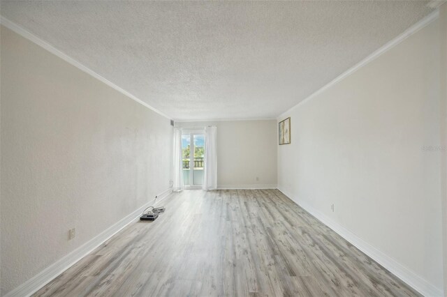 spare room featuring crown molding, a textured ceiling, and light hardwood / wood-style floors