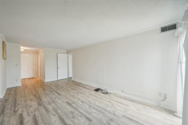 interior space featuring light hardwood / wood-style floors, a textured ceiling, and crown molding