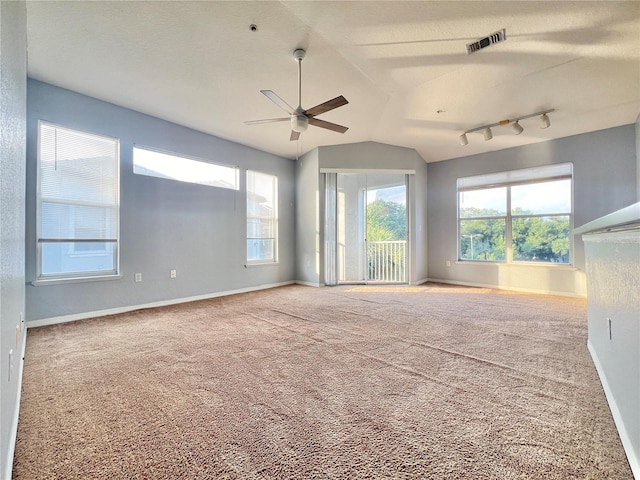 spare room with carpet flooring, a textured ceiling, ceiling fan, vaulted ceiling, and track lighting