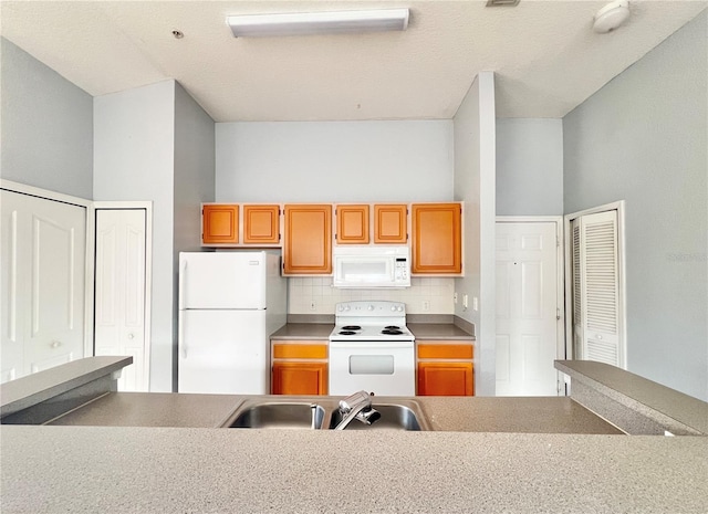 kitchen with sink, decorative backsplash, and white appliances