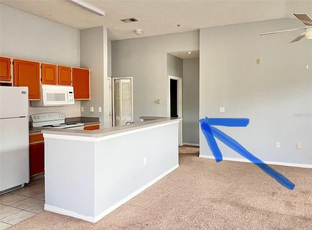 kitchen featuring light carpet, ceiling fan, a kitchen island, and white appliances