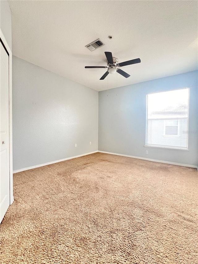 carpeted empty room featuring ceiling fan