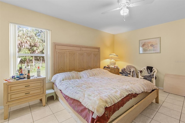 bedroom featuring ceiling fan, light tile patterned floors, and multiple windows