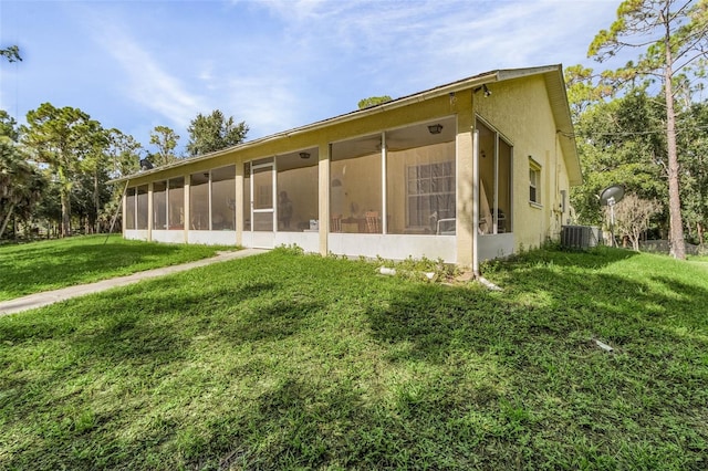 rear view of house with a yard and a sunroom