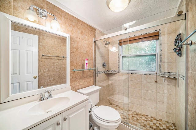 bathroom with a textured ceiling, walk in shower, vanity, and toilet