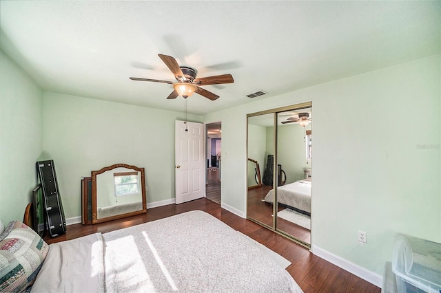 bedroom with ceiling fan, dark wood-type flooring, and a closet