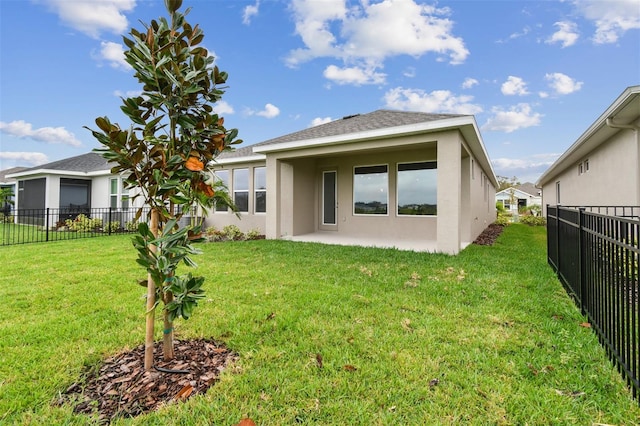 rear view of property featuring a patio and a yard