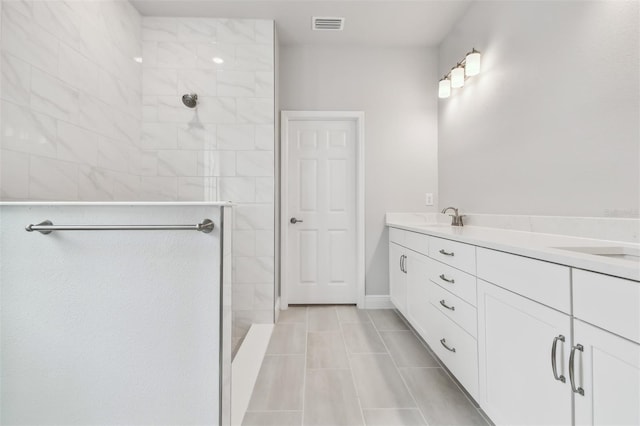 bathroom with vanity and tiled shower