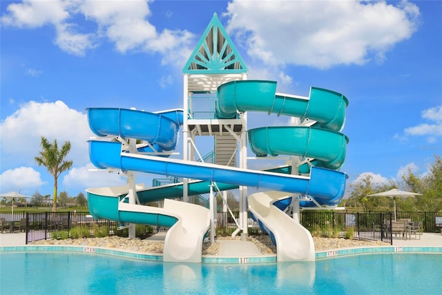 view of swimming pool featuring a playground and a water slide