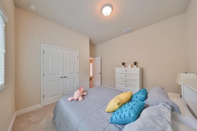 bedroom with light colored carpet and a closet