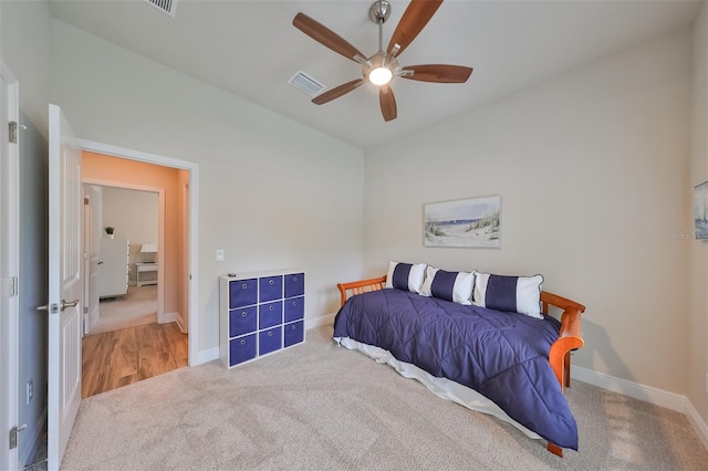 bedroom with vaulted ceiling, light colored carpet, and ceiling fan