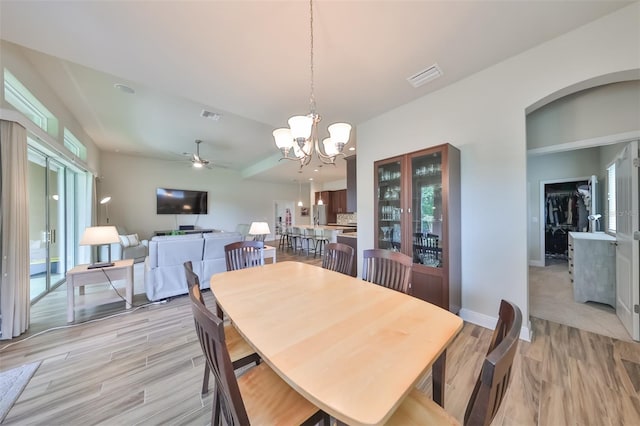 dining space featuring ceiling fan with notable chandelier and light hardwood / wood-style flooring