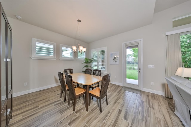 dining space with an inviting chandelier, a wealth of natural light, and light wood-type flooring