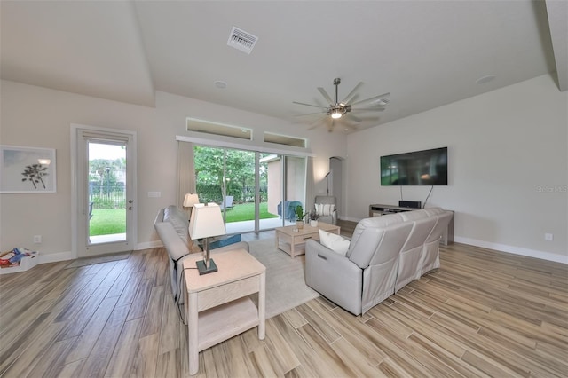 living room featuring ceiling fan, plenty of natural light, and light hardwood / wood-style floors