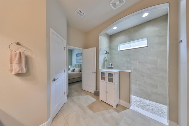 bathroom featuring tiled shower and tile patterned floors