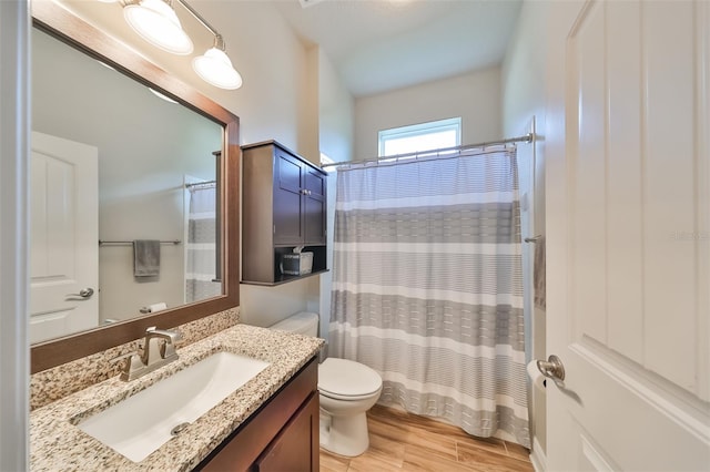 bathroom with vanity, hardwood / wood-style floors, toilet, and walk in shower