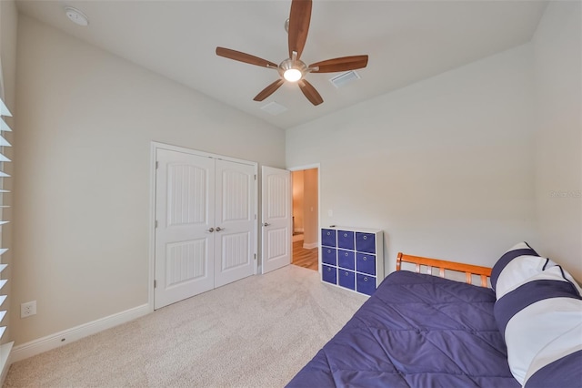 bedroom with lofted ceiling, carpet flooring, ceiling fan, and a closet