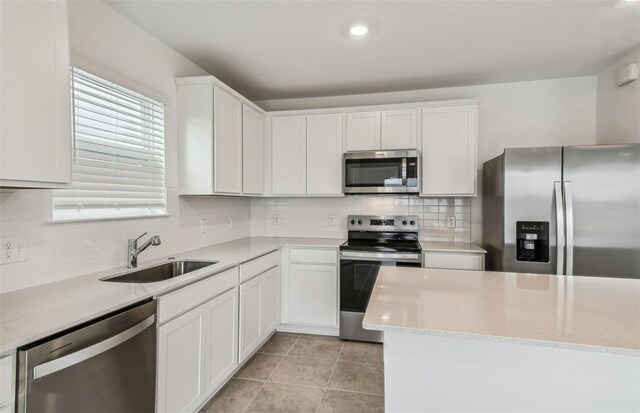 kitchen featuring white cabinetry, stainless steel appliances, tasteful backsplash, and sink