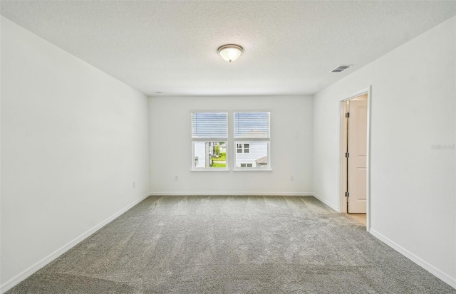 unfurnished room featuring carpet and a textured ceiling