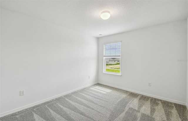 carpeted empty room featuring a textured ceiling