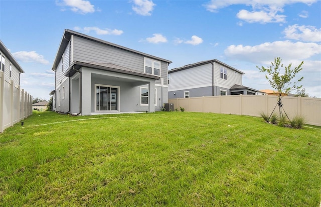 rear view of property with a yard and central AC