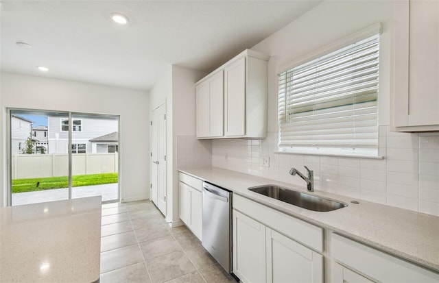 kitchen with sink, dishwasher, backsplash, white cabinets, and light stone counters