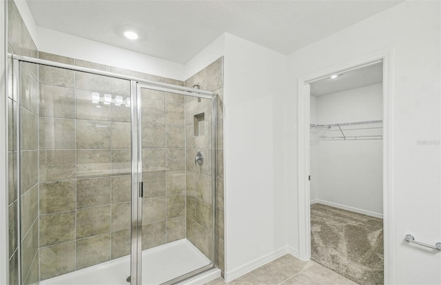 bathroom with an enclosed shower and tile patterned flooring