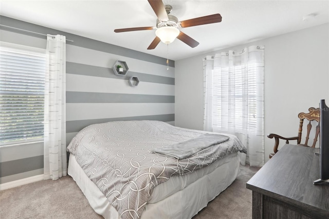 bedroom with ceiling fan, multiple windows, and carpet