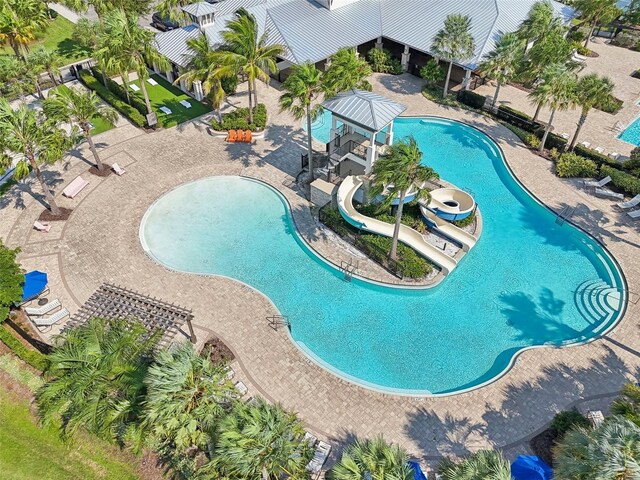 view of swimming pool featuring a water slide and a patio area