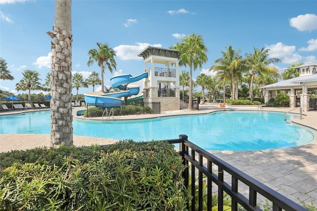 view of pool featuring a water slide and a playground