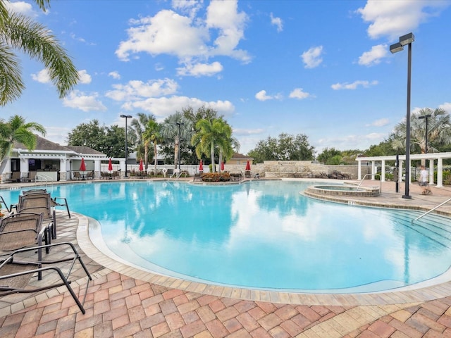 view of pool featuring a community hot tub and a patio area