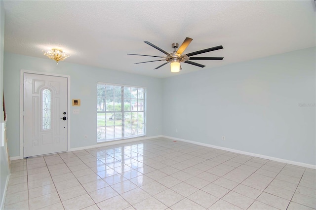 foyer featuring a textured ceiling, ceiling fan, and light tile patterned flooring