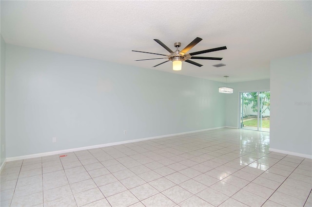 unfurnished room featuring light tile patterned flooring, ceiling fan, and a textured ceiling