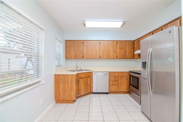 kitchen with light tile patterned floors, appliances with stainless steel finishes, and sink