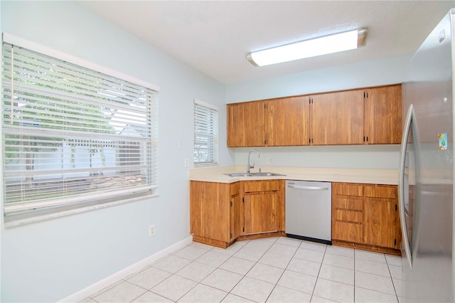 kitchen featuring light tile patterned flooring, sink, stainless steel refrigerator, and dishwashing machine