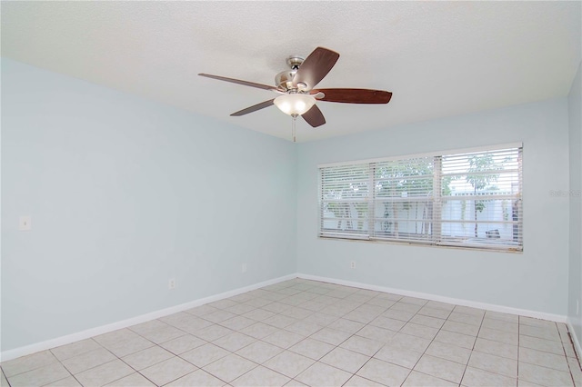 tiled spare room featuring ceiling fan