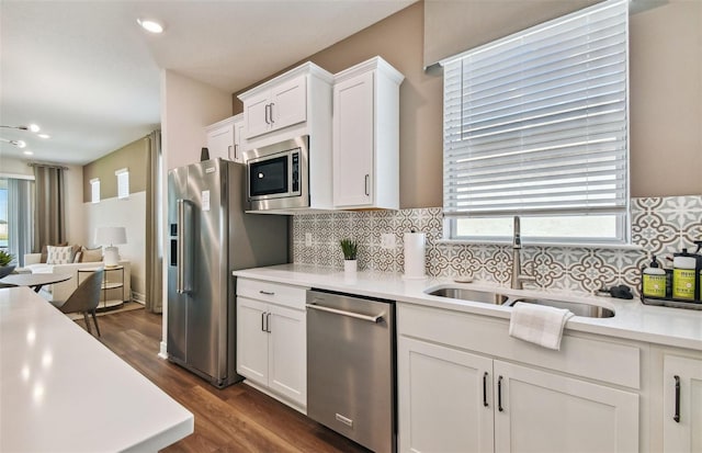 kitchen featuring appliances with stainless steel finishes, sink, dark wood-type flooring, and white cabinets