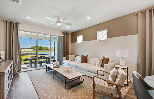 living room with ceiling fan and hardwood / wood-style flooring