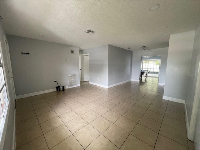 tiled spare room featuring a textured ceiling