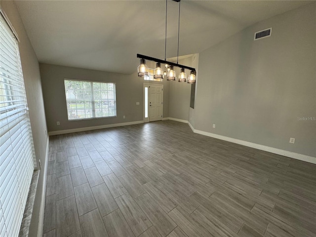 empty room with vaulted ceiling and wood-type flooring